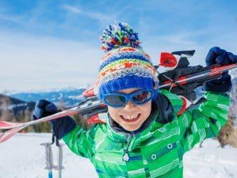 Portrait of Cute happy skier boy in a winter ski resort.