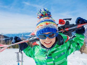 Portrait of Cute happy skier boy in a winter ski resort.